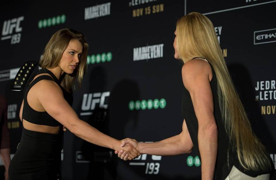 RouseyandHolmprefight - MyMMANews (L-R) UFC women's bantamweight champion Ronda Rousey of the United States shakes hands with Holly Holm of the United States during the UFC 193 Ultimate Media Day festivities at Etihad Stadium on November 13, 2015 in Melbourne, Australia. (Photo by Brandon Magnus/Zuffa LLC)
