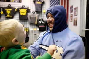 Asher Bozik,2, plays with his father Joey's hood strings at Tier 1.