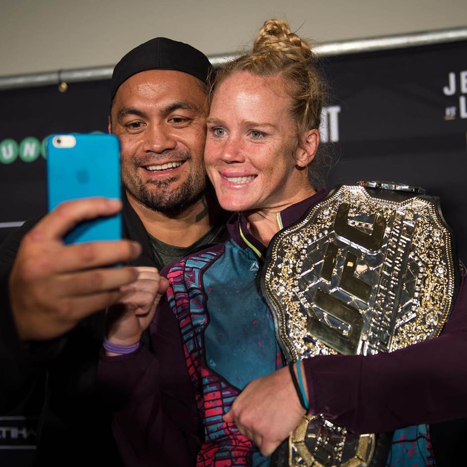 UFC women's bantamweight champion Holly Holm poses for a photo at the UFC 190 post fight press conference with heavyweight Mark Hunt.